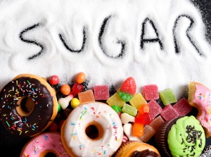 mix of sweet cakes, donuts and candy with sugar spread and written text in unhealthy nutrition, chocolate abuse and addiction concept, body and dental care
